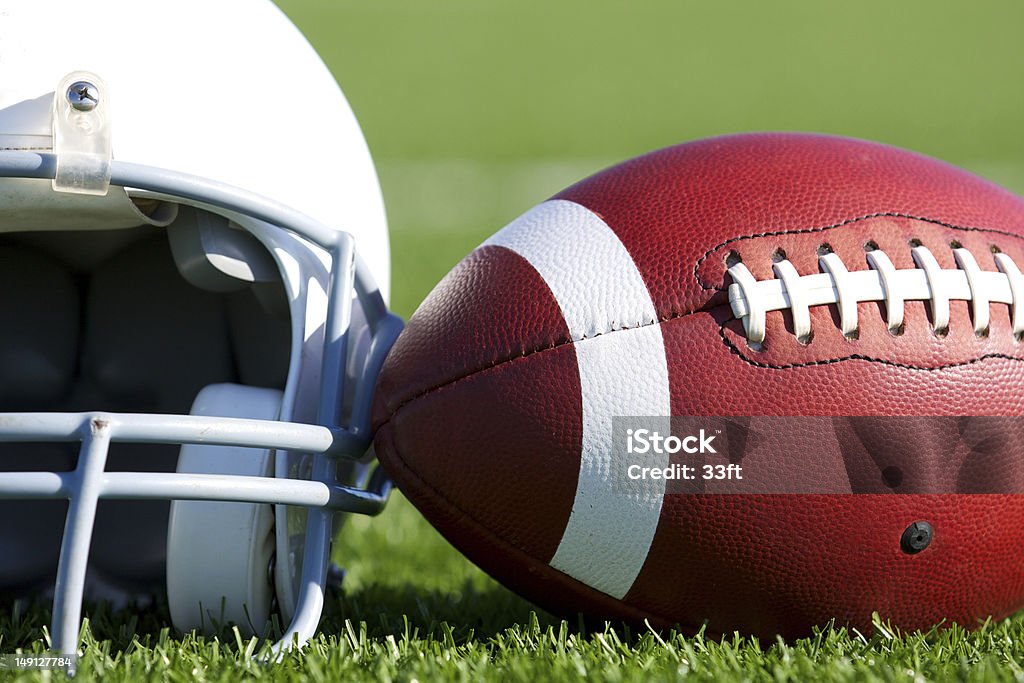 De futebol e capacete em campo - Foto de stock de Capacete de Futebol Americano royalty-free