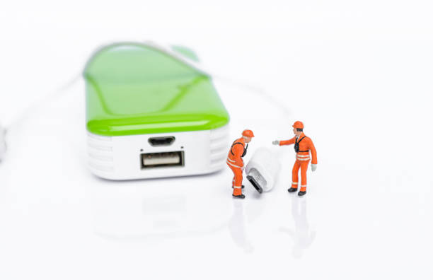 Miniature worker with USB cable and power bank isolate on white background, energy storage,  technology industry