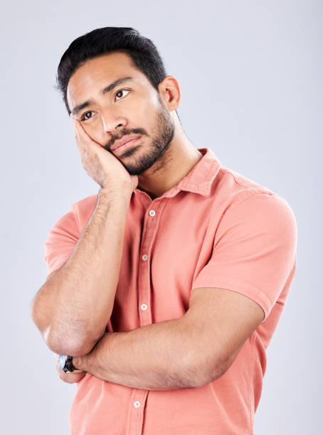 istock Sad, depression and bored with a man in studio on a gray background feeling lonely or unhappy. Thinking, boredom and alone with a handsome young male feeling depressed, tired or regret indoor 1491280974