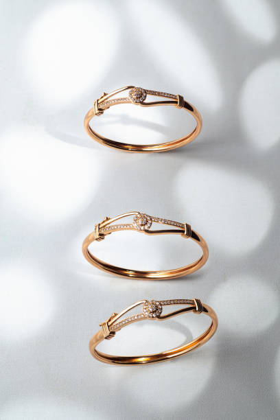 istock Top view of three gold bracelets on white background with unique shadow effect 1491281805