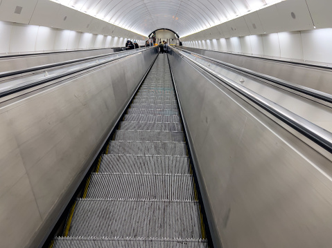 escalator, escalator of metro or subway downstairs into the station. downstairs into a station of a metro or subway interior. Transportation background or surface concept photo with copy space