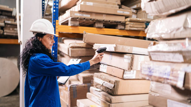 istock Female worker holding RFID scanner and scanning parcel barcode in delivery  warehouse 1491287151