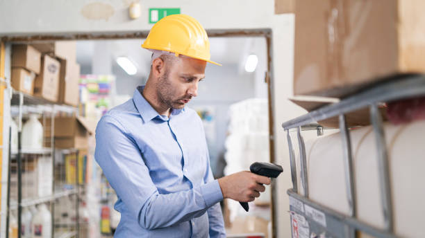 istock Male worker holding RFID scanner and scanning parcel barcode in delivery warehouse 1491287164