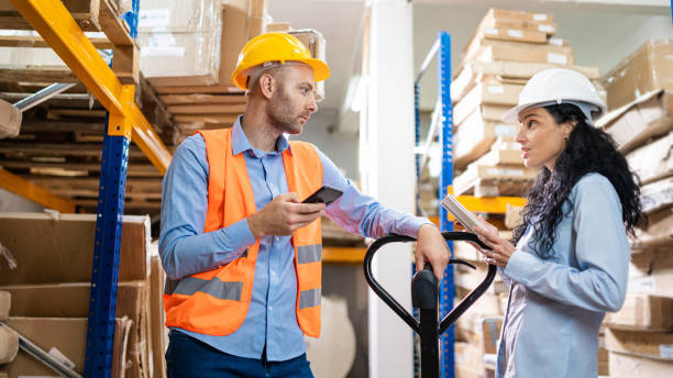 istock Male worker holding smartphone while making a check in delivery warehouse 1491287188