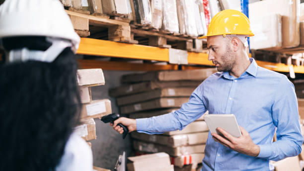 istock Male worker holding RFID scanner and scanning parcel barcode in delivery warehouse 1491287189