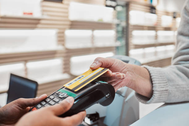 istock Hands, credit card and machine for payment, banking transaction or ecommerce at eye clinic or store. Hand of customer tapping debit in transact for purchase, electronic pay or POS at optometry shop 1491289521