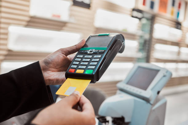 istock Hands, credit card and machine for banking transaction, ecommerce or payment at clinical store. Hand of customer making purchase or debit insert for electronic pay, bank or buying at optometry shop 1491289533