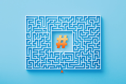 Orange hashtag symbol sitting at the center of a white maze  on blue background. Horizontal composition with copy space. Solution concept.