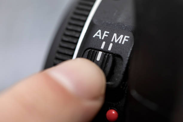 Fingers selecting autofocus AF on a professional camera lens. man putting AF mode autofocus on lens photos. Man selecting in Close up of AF switch on camera lens