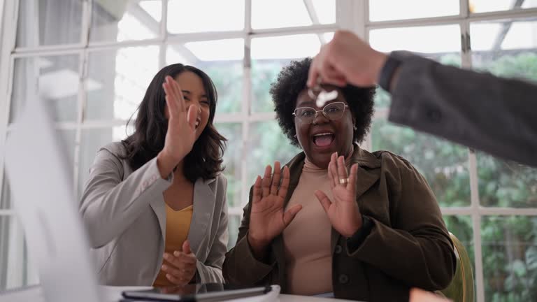 Women on a real estate meeting and celebrating new house keys