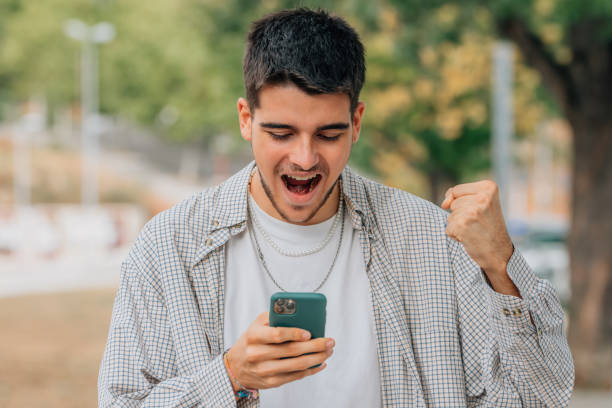 istock young man with mobile phone euphoric with expression of success 1491292227