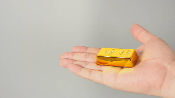 istock Gold bar in hand isolated on gray background. 1491292408