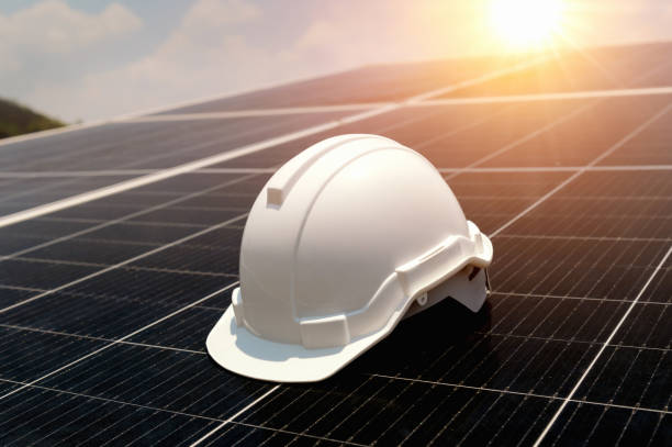 istock safety helmet on solar panel with turbine background. eco environment concept 1491293346