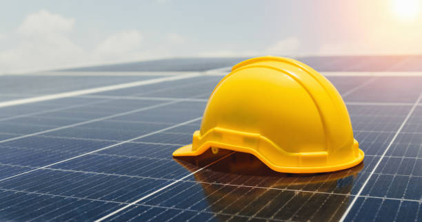 istock safety helmet on solar panel with turbine background. eco environment concept 1491293355