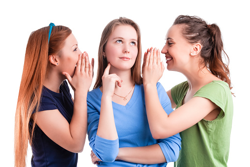 Three Winsome Caucasian Girlfriends Sharing Their Secrets Whispering to Ears Isolated Over White Background.Horizontal Image