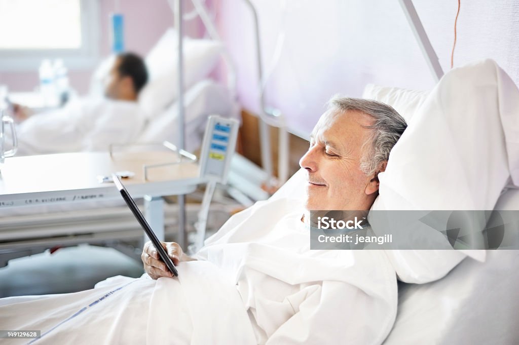 Lectura tableta electrónica en el hospital - Foto de stock de Paciente libre de derechos