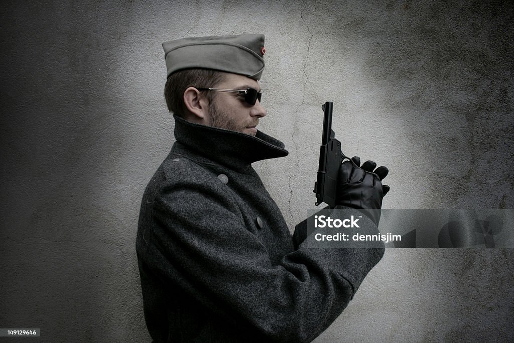 Bad guy holding gun A sinister looking person holding a gun Gun Stock Photo