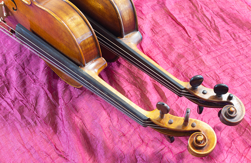 Two violins on a red background.