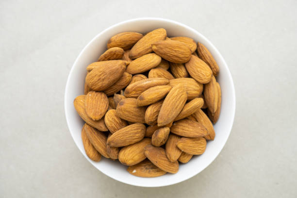 istock stack of almonds in a white bowl on gray background high quality closeup shot 1491301176
