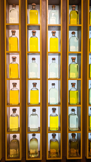 Shelf with olive oil bottles of different colors in Spain