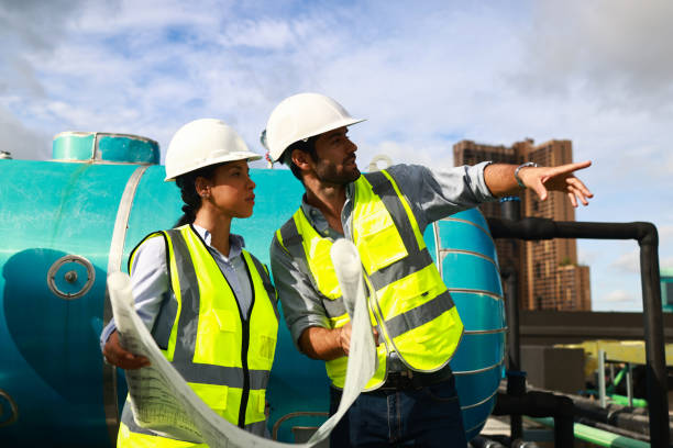 istock Chief engineer and site engineer working together on rooftop of new  building. Project engineer team discussing on the drawing at site line 1491304428