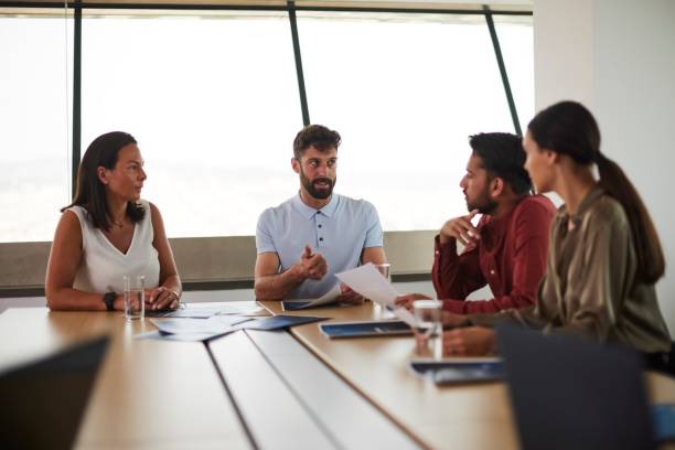 istock Empowered by Collaboration: Small Business Group Gathers Around Meeting Table for Strategy Session 1491307019