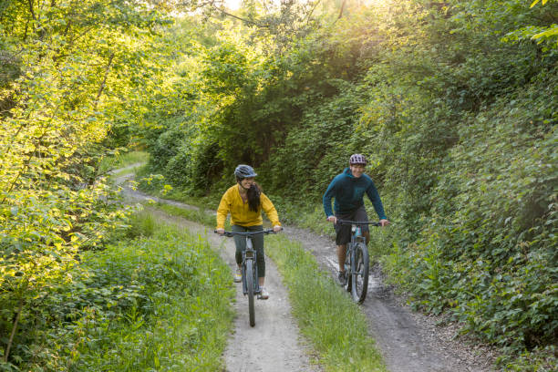istock Young couple ride mountain bikes down rural road 1491308023