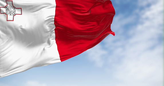 Malta national flag waving in the wind on a clear day. White and red with George Cross in white stripe canton. 3d illustration render. Fluttering fabric.