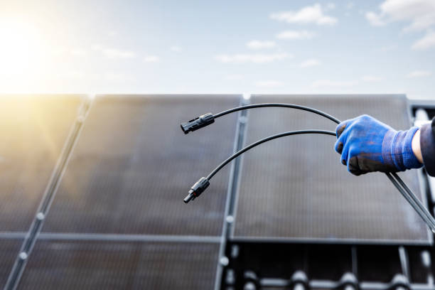 Solar panel cables with MC4 connectors held by a hand stock photo