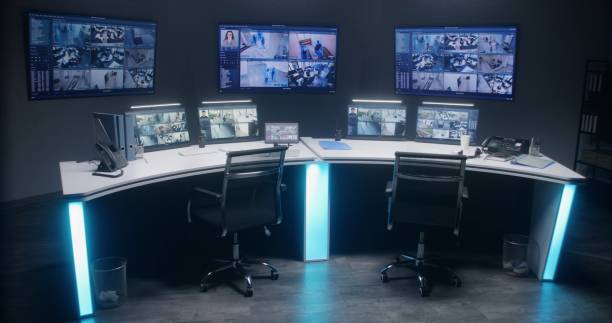 Workspace in security control center with computers and big digital screens stock photo