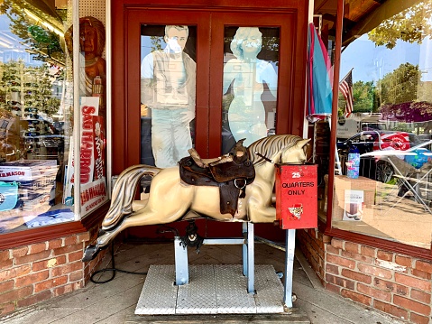 Sag Harbor, NY, USA, 8.6.21 - A vintage, old mechanical ride for children. It's a horse with a saddle that moves up and down when a quarter is put into the machine.