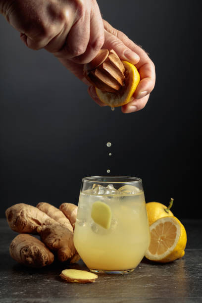 Ginger Ale with ice and lemon on a black background. stock photo