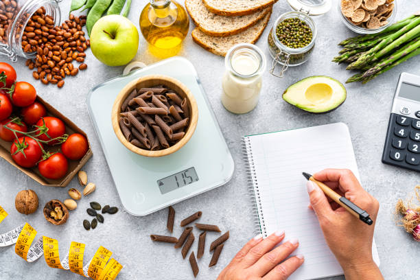 Using kitchen scale to calculate the right portion of healthy vegan diet stock photo