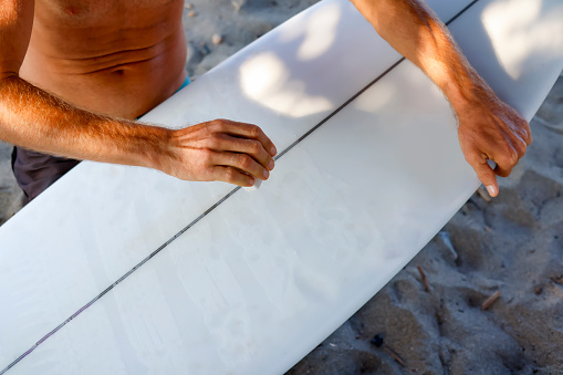 Surfer waxing the board