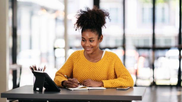 istock African american student woman in sweater watching e-learning to 1491315327