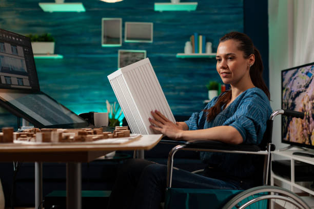 istock Disabled engineer sitting in wheelchair with maquette 1491316829