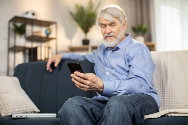 istock Grandfather texting message via phone app from home 1491316864