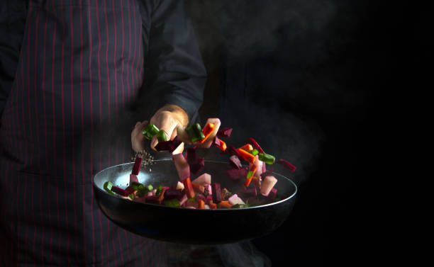 istock Cooking vegetables by chef hands on black background copy space. Food concept. Vegetable menu for the hotel. 1491317563