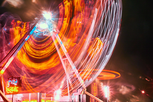 Image of Red, white and orange streaks of light from a carnival or fair ride