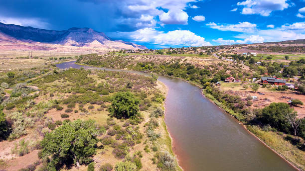 istock River next to small desert town with mountains and storm clouds in distance 1491318665