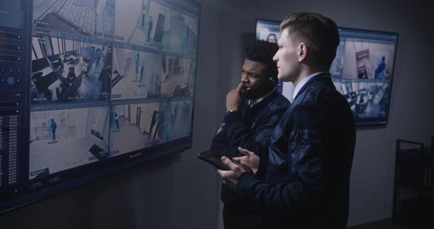 istock Officer monitors cameras and talks with colleague 1491318785