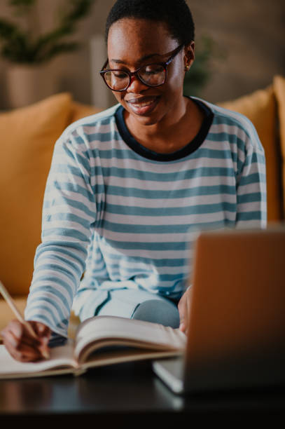 istock African american woman using laptop while sitting on a sofa at home 1491318819