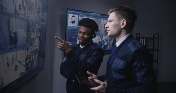 istock Officer monitors cameras and talks with colleague 1491318872