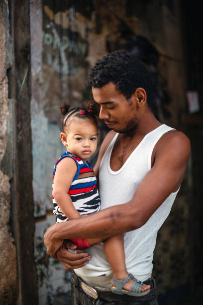 Young Cuban father holding his little daughter in Havana, Cuba stock photo