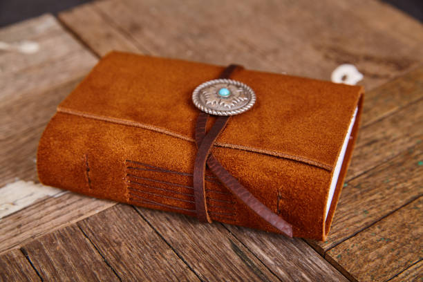istock Small closed leather journal with concho and thread on wood boards 1491320497
