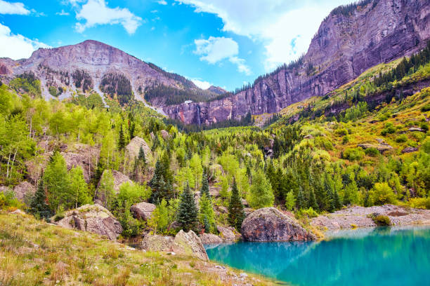 istock Small lake tucked into mountain valley near fall with waterfall in background 1491320539