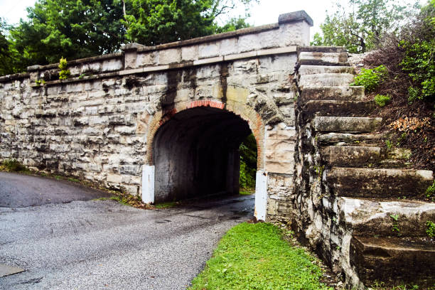 istock Small road going under stone tunnel with stone steps to the top 1491320560