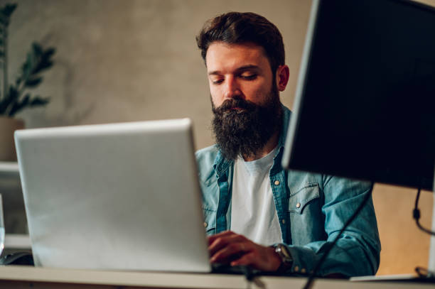 istock A young AI web app developer is programming a new generation of an AI website at his cozy home at night while sitting surrounded by two monitors. 1491320561