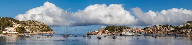 Panoramic view of Port de Soller, Mallorca. Summer tourist resort with boats floating on sea.