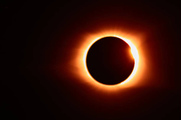 istock Solar eclipse with solar flare that makes for an orange glow around the black moon 1491320711